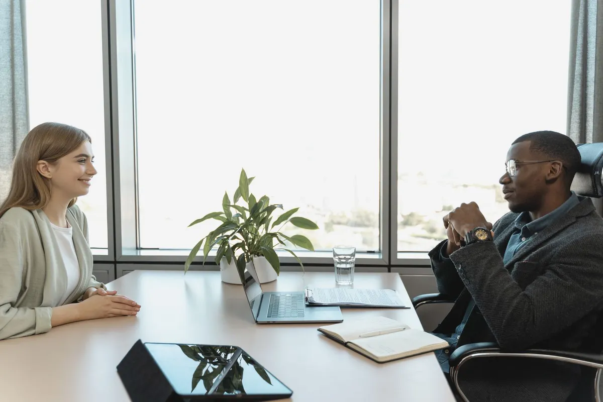 Deux professionnels échangent autour d'un dossier salarial, graphiques et notes sur la table